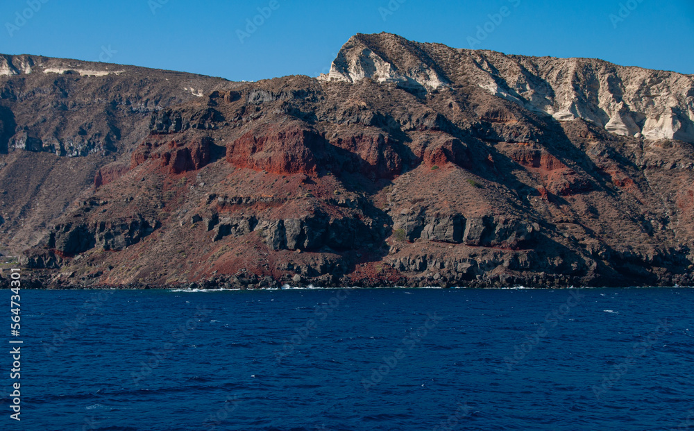 A red, brown and white Cliff of Santorini during a sunny day
