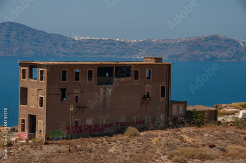 An abandoned house on the ciffs of Santorini during a summer day photo