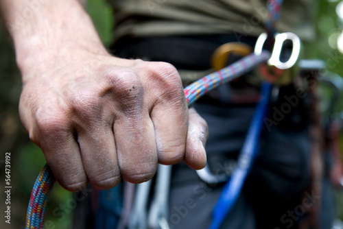 A hand holds the rope tight to prevent the climber above from falling far, Zig Zag, Oregon.