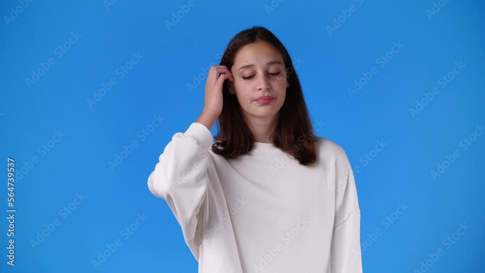 4k slow motion video of one girl with negative facial expression over blue background. 4k slow motion video of one girl with negative facial expression over blue background.