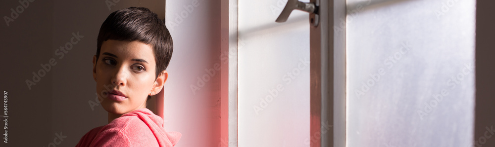 Young girl cancer patient standing in front of the hospital window Young girl cancer patient standing in front of the hospital window