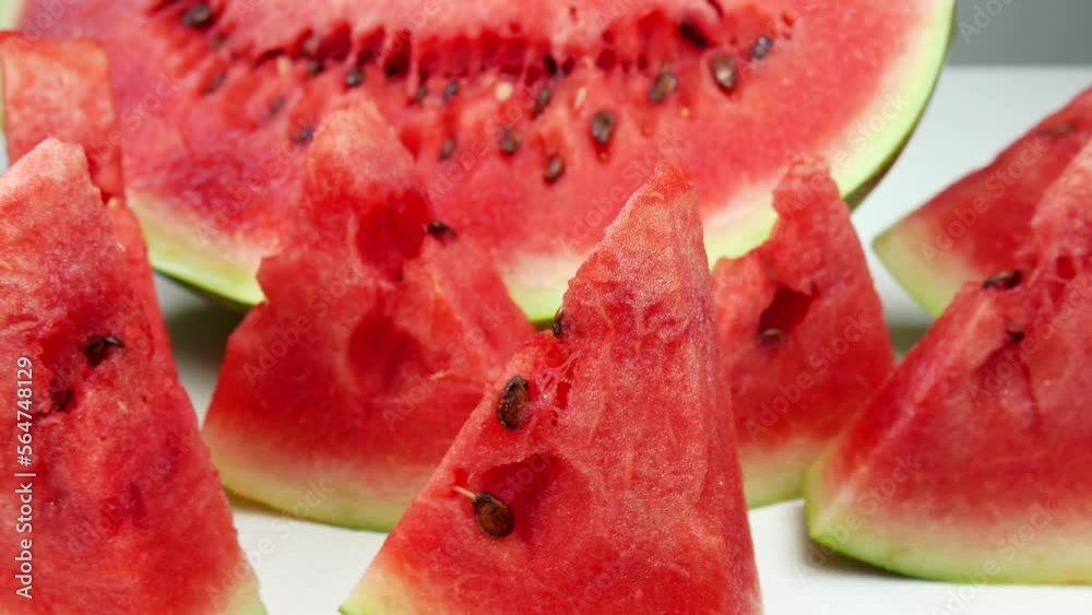 Watermelon lies on the table. Sliced watermelon and melon lie on a white background. Fresh fruit on the counter.