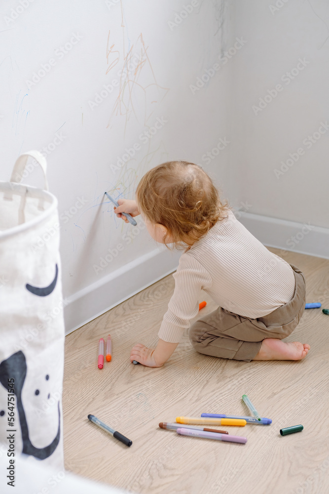 Foto de One year child scribbling on white wall at home. Little kid ...