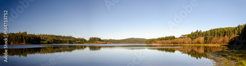 Panoramic view of a lake where the trees are reflected in a water