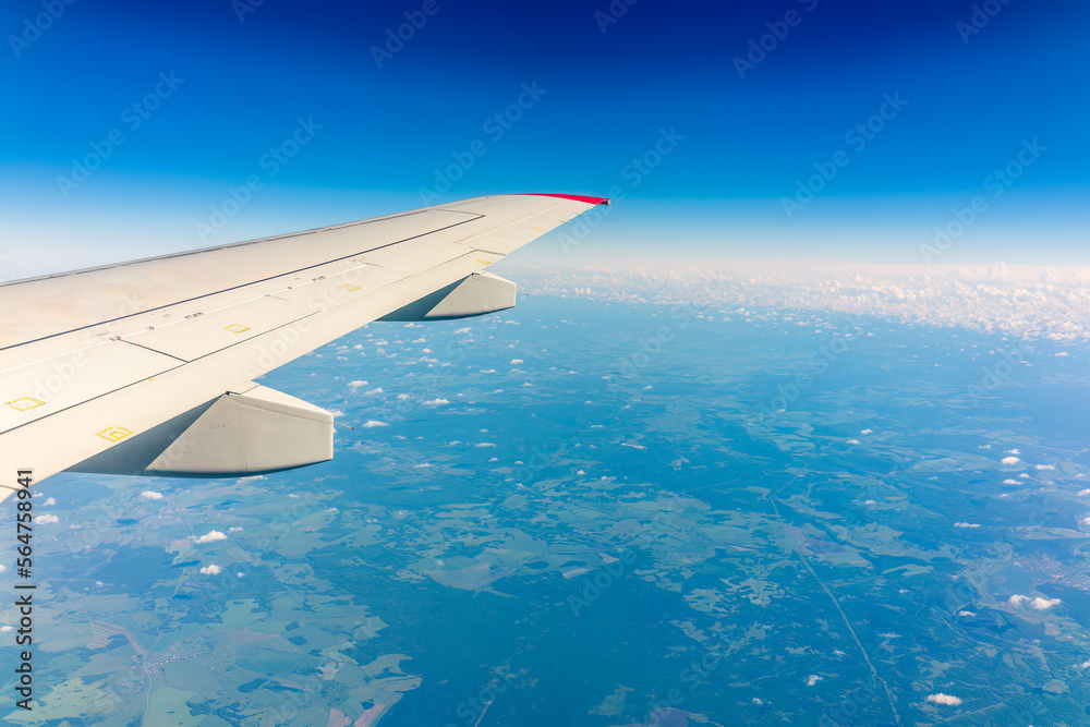 Obraz premium View from the airplane window at a beautiful cloudy sky and the airplane wing