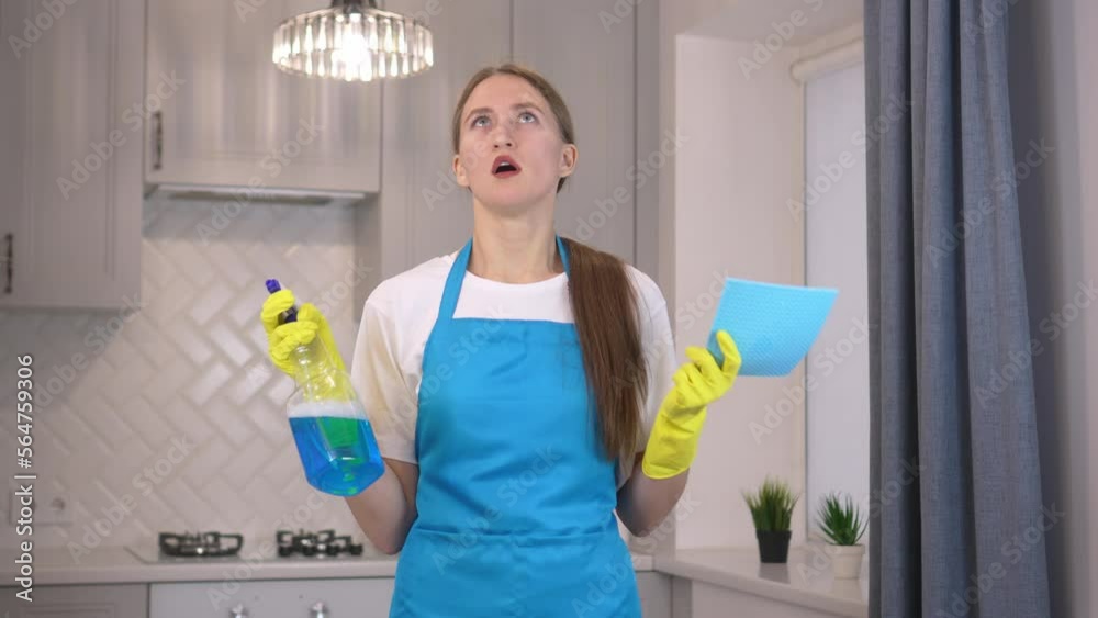Beautiful brunette young woman in blue apron holding cleaning products, angry and crazy screaming upset and furious, screaming with anger as she looks up. Tired frustrated and exhausted cleaner Beautiful brunette young woman in blue apron holding cleaning products, angry and crazy screaming upset and furious, screaming with anger as she looks up. Tired frustrated and exhausted cleaner