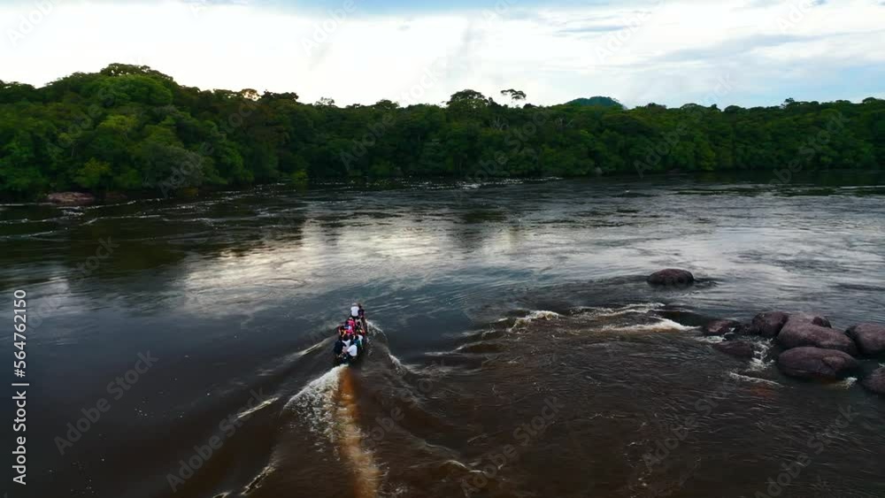 Close aerial view in motion of a boat crossing a mighty river in the middle of the Colombian jungle of Vaupes in Colombia 4K Close aerial view in motion of a boat crossing a mighty river in the middle of the Colombian jungle of Vaupes in Colombia 4K