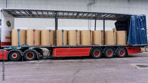 Semi Truck Trailer Loaded with Paper Reels and Secured Cargo Side View