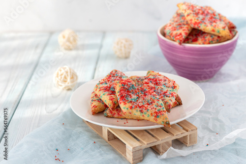 Homemade cookies with colored sugar on a light wooden background. 