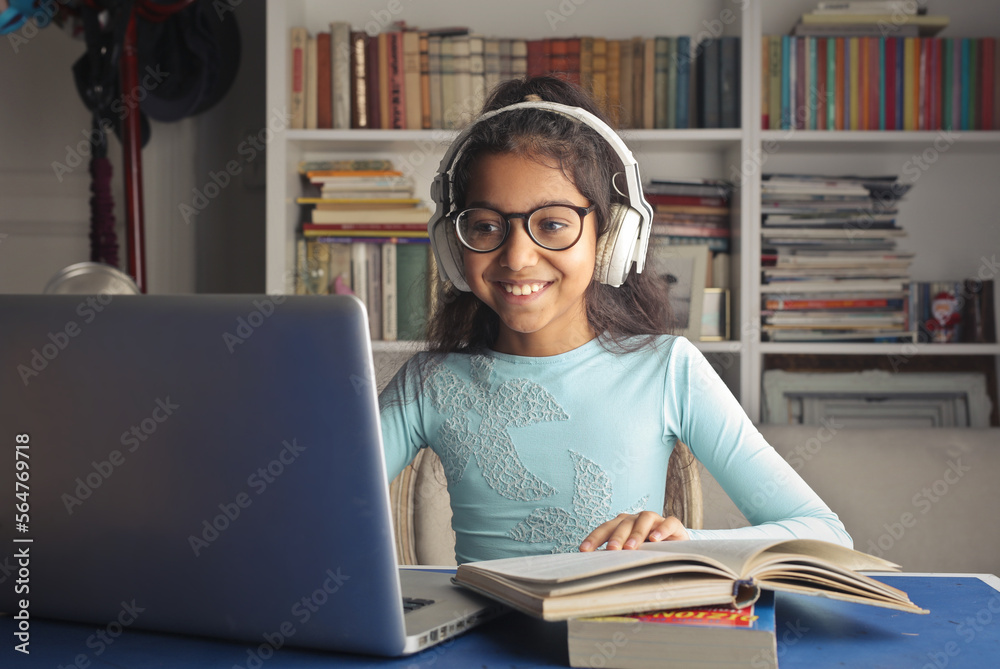 little girl in her bedroom doing homework using a computer little girl in her bedroom doing homework using a computer
