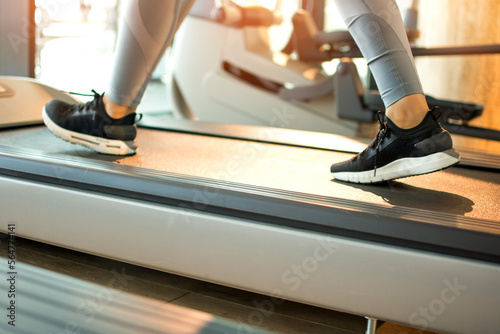 Legs of woman running on a treadmill in gym  close-up.