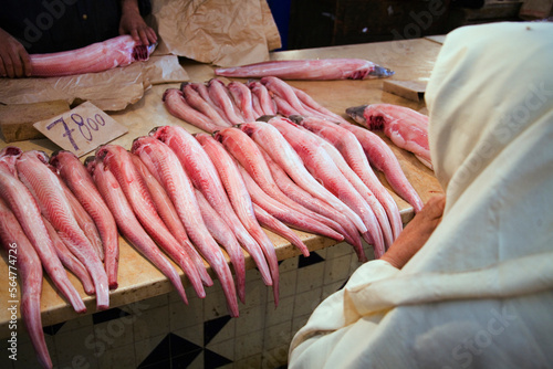 A fishmonger selling fish to a Muslim woman wearing white Hijab. photo