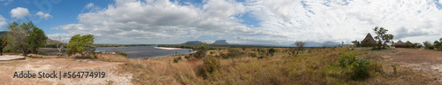 Distant view of grass huts and tepui mountain, Canaima National Park, Venezuela photo