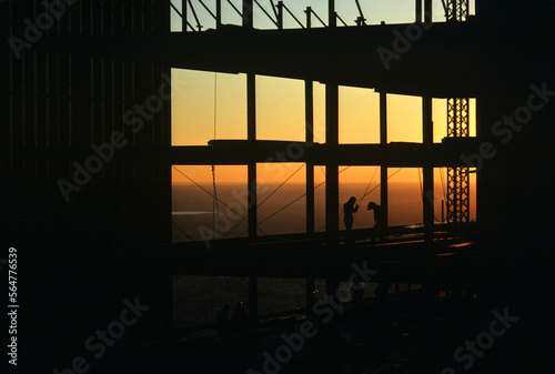 Silhouette of construction workers on high rise commercial building in Dallas, TX. photo