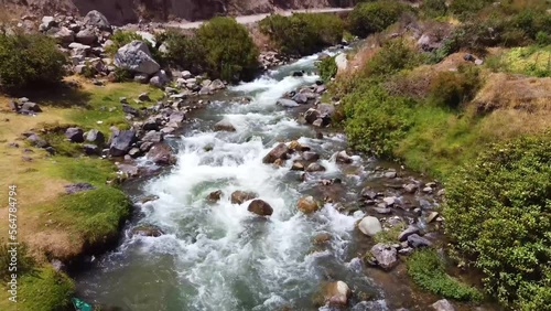 Overtake Shot Of Flowing River Through Green Wild Nature, Obrajillo, Peru photo