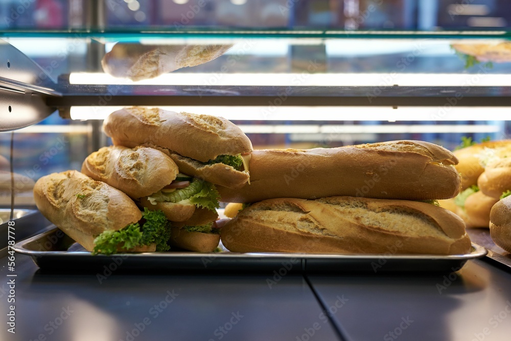 a pile of handmade sandwiches on a store shelf