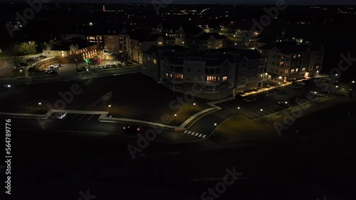 Aerial view of car driving in retirement home community at night. Large assisted living facility in America at dark. photo