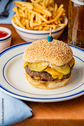 Hamburger. Bacon Cheeseburger. Classic traditional American bar, restaurant entree. Beef hamburger with Swiss and cheddar cheeses served with lettuce, tomato, onion and hand cut french fries. 