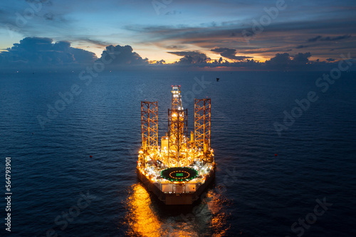 Aerial view of jack up drilling rig in the middle of the ocean while rig move at night time