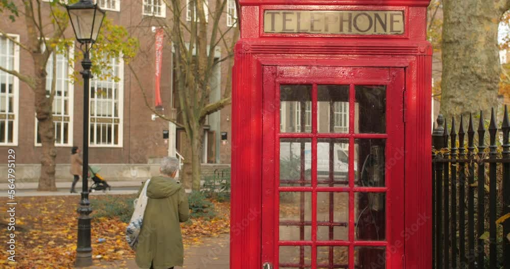 Traditional Red Telephone Box On A Street In London During Autumn In England, UK. Tilt-down Traditional Red Telephone Box On A Street In London During Autumn In England, UK. Tilt-down