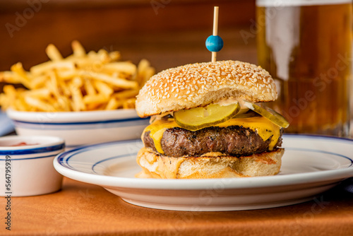 Hamburger. Bacon Cheeseburger. Classic traditional American bar, restaurant entree. Beef hamburger with Swiss and cheddar cheeses served with lettuce, tomato, onion and hand cut french fries. 