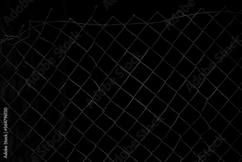 Old net Fence. close up image. aged and dirty steel metal wall. close-up. dark empty room space.