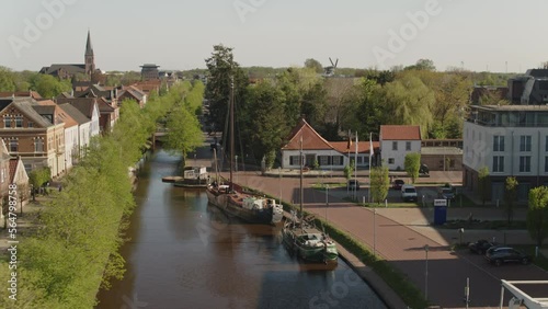 Canal with historical buildings and boats in north germany in Papenburg drone shot photo