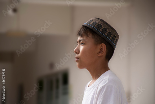 Portrait of southeat asian muslim boy in white shirt and wears hat, soft and selective focus. photo