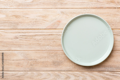 Top view of empty blue plate on wooden background. Empty space for your design