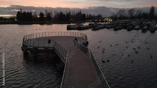 Fly over the pier at sunset at Billing Aquadrome lake. photo