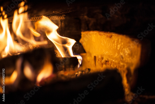 Raclette cheese is melted by a wood fire at a backcountry inn inside the Parc Naturel RÃ©gional du Vercors, France. photo