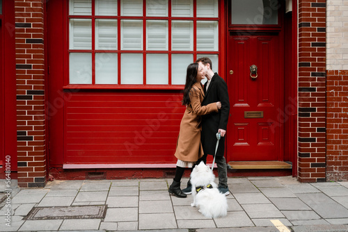 Happy lovers with their dog have fun outdoor photo