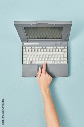 90s laptop with female hand pressing space bar. photo