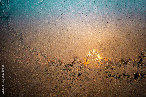 Colorful sunset shot through a frosty window