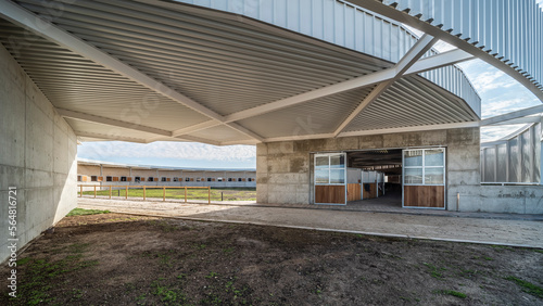 Front view of a modern circular design horse ranch at daylight photo