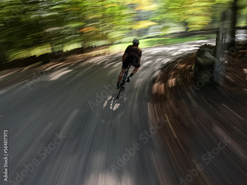 following a cyclist pedalling on a mountain road photo