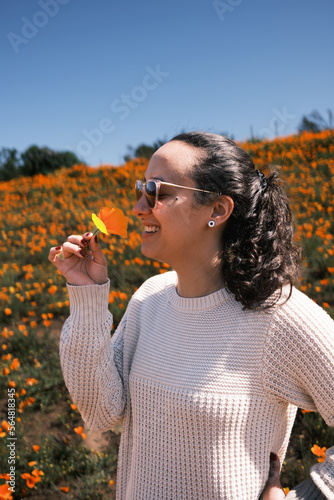 woman holding an orange flower in her hands photo