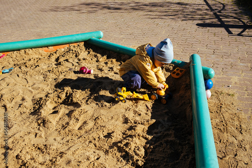 A little boy is playing in the sandbox. photo