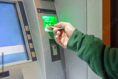 man inserting a credit card into an ATM photo