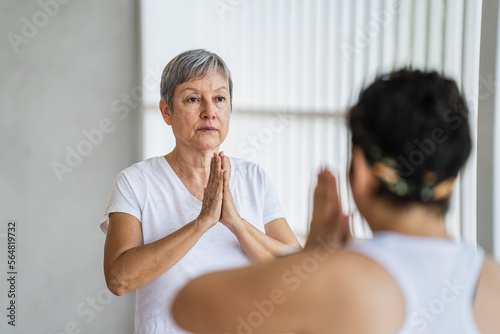 Student receiving indications when making mudras in yoga class photo