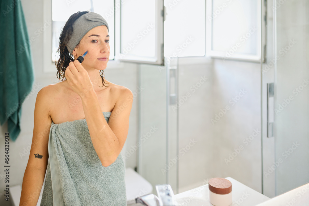 Woman apply face serum.