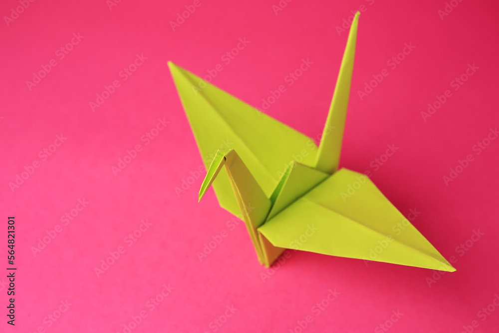 Origami art. Handmade paper crane on pink background, closeup. Space for text Origami art. Handmade paper crane on pink background, closeup. Space for text