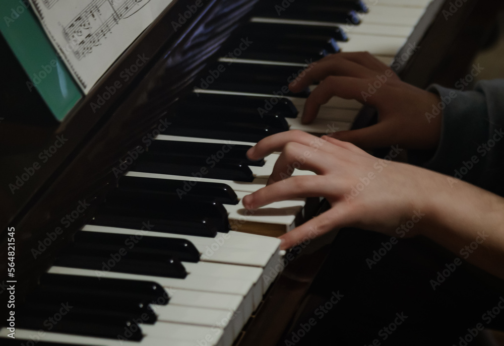 Obraz premium Child's hands playing the piano. A child plays the piano. Learning music. Two hands on the piano, Two hands on the keys