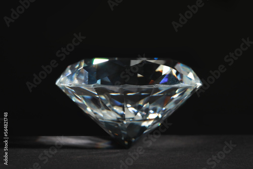 Beautiful dazzling diamond on dark background  closeup. Precious gemstone