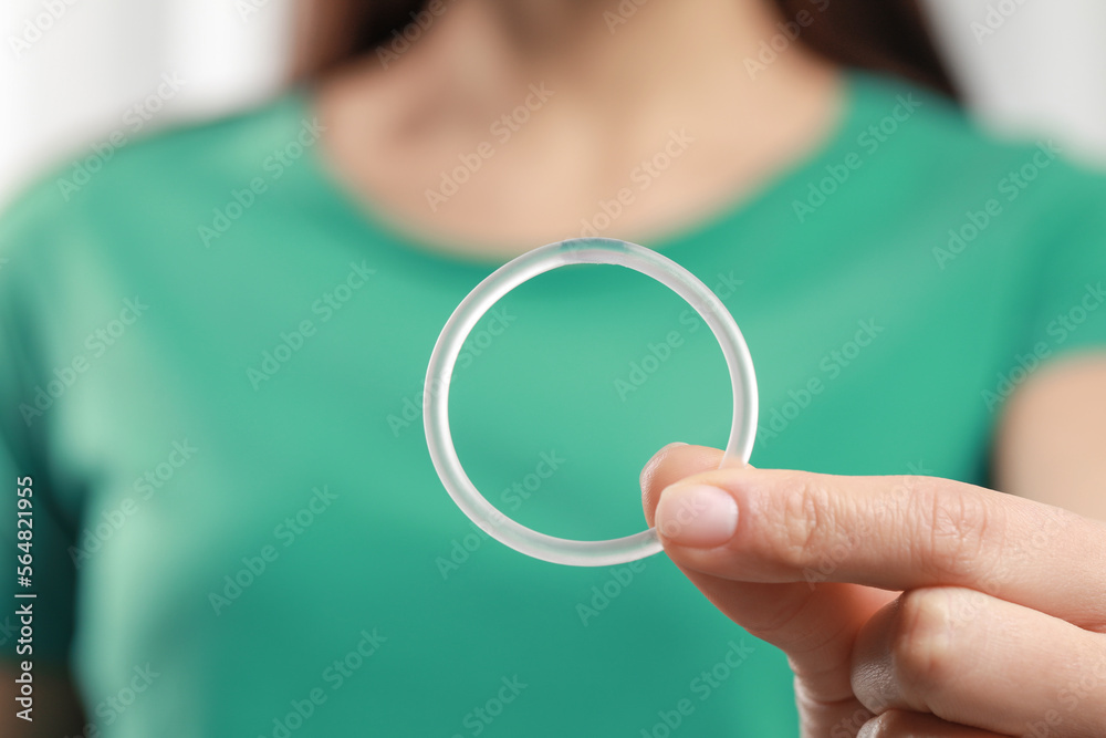 Woman holding diaphragm vaginal contraceptive ring on blurred ...