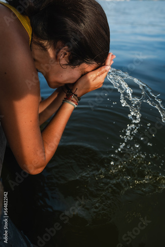 woman splashing salt water from a lake on her face photo