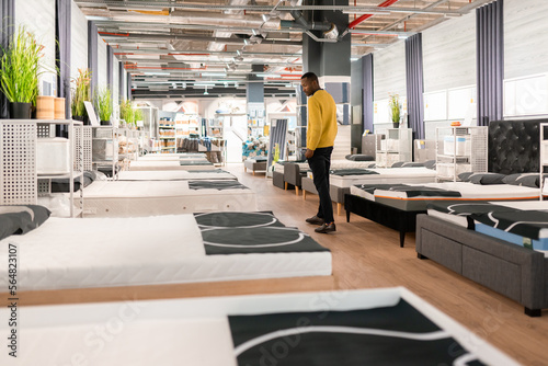 Man Looking At Mattress In The Shop photo