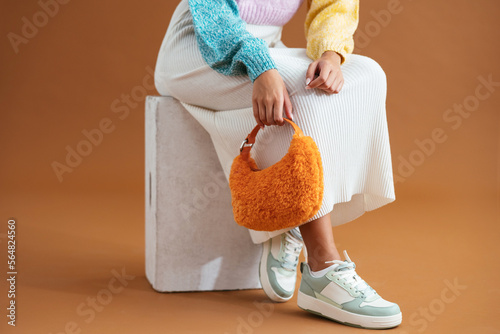 Crop stylish woman sitting on box photo