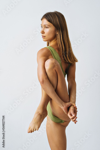 Graceful woman practicing yoga in white studio photo