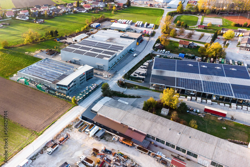 Industry with low carbon footprint. Industrial warehouses with solar panels on the roof. Aerial view 